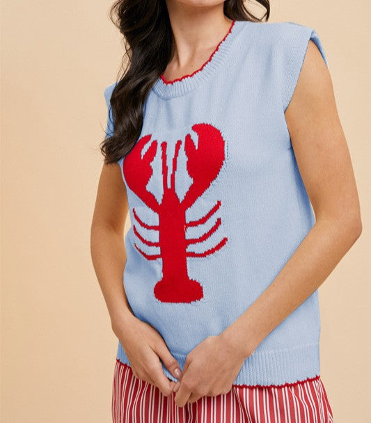 Woman wearing a light blue sleeveless knit sweater tank featuring a bold red lobster graphic – fun nautical summer top for women
