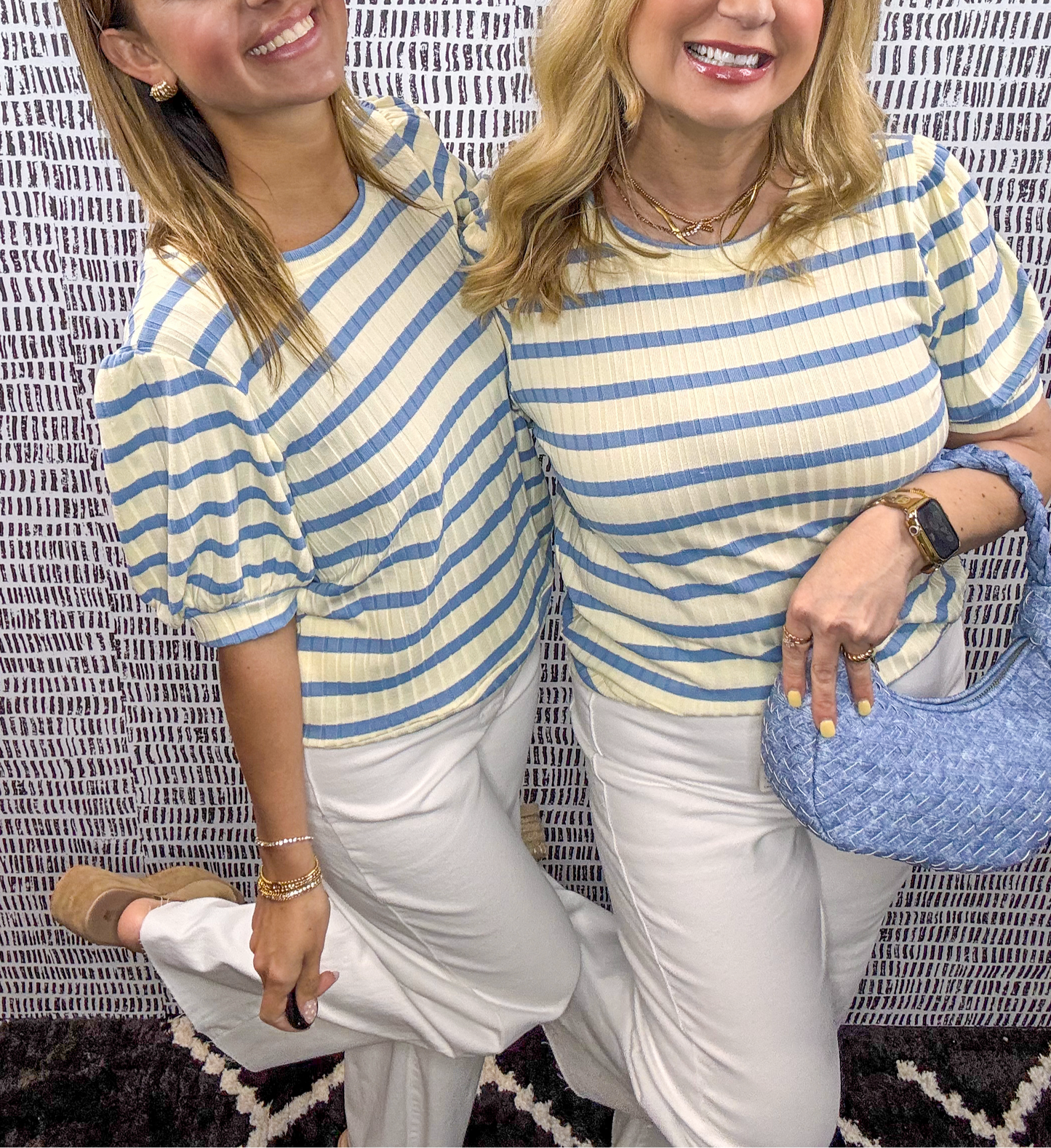 Two women wearing butter yellow and blue striped puff sleeve tops paired with white pants and gold jewelry – light and airy spring or summer outfit inspiration