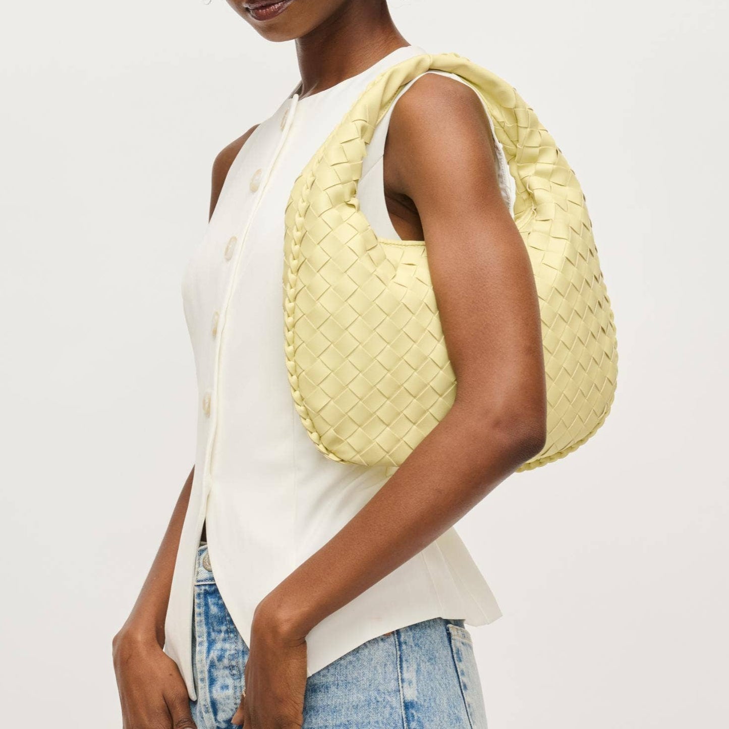 Model wearing butter yellow woven hobo bag over the shoulder, styled with white sleeveless top and denim – Erin Rose Boutique