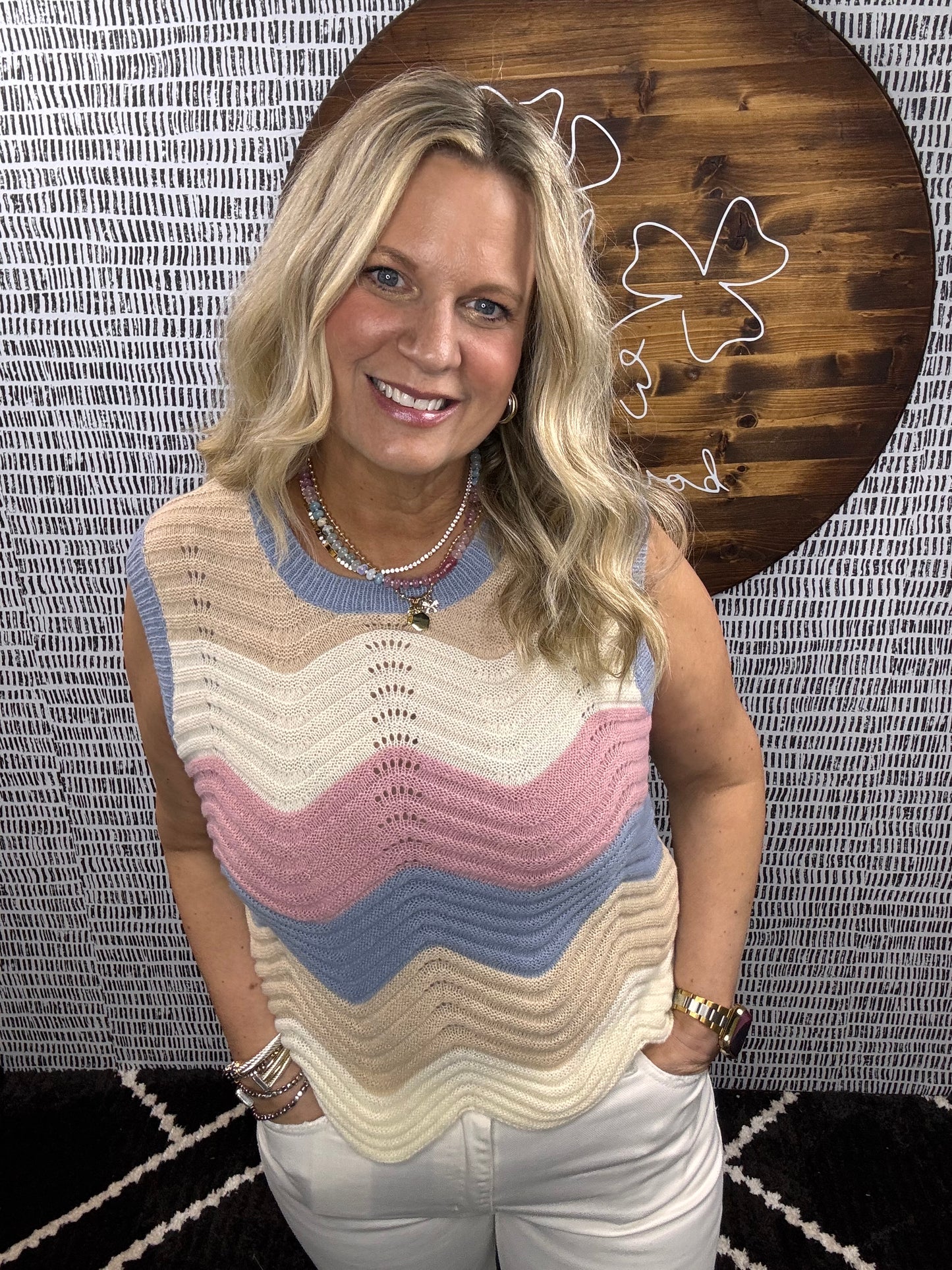 Close-up of model wearing pastel chevron knit sleeveless top with pink, blue, and tan stripes – Erin Rose Boutique