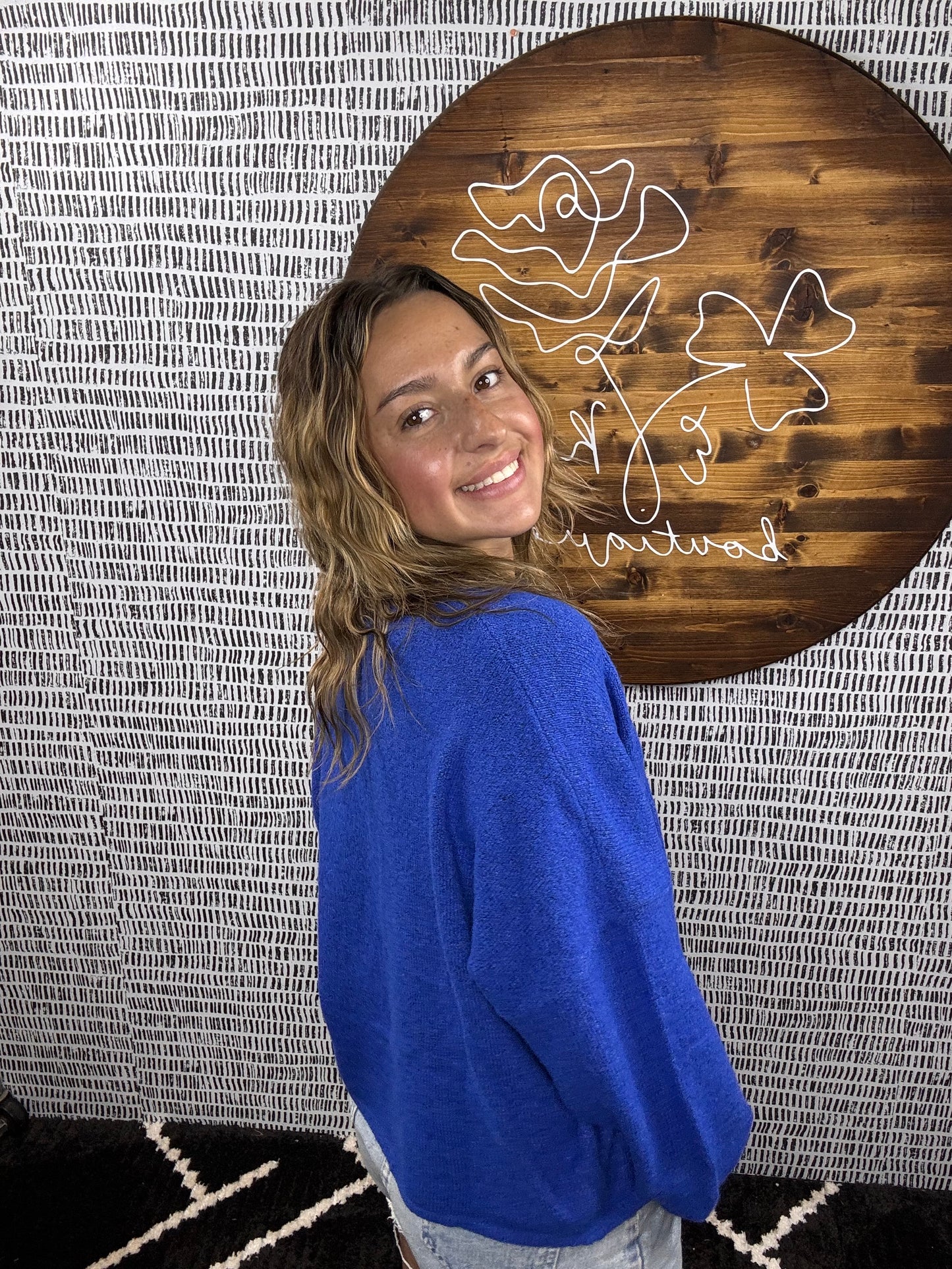 Back view of model wearing cobalt blue cardigan with relaxed fit and denim shorts – Erin Rose Boutique.