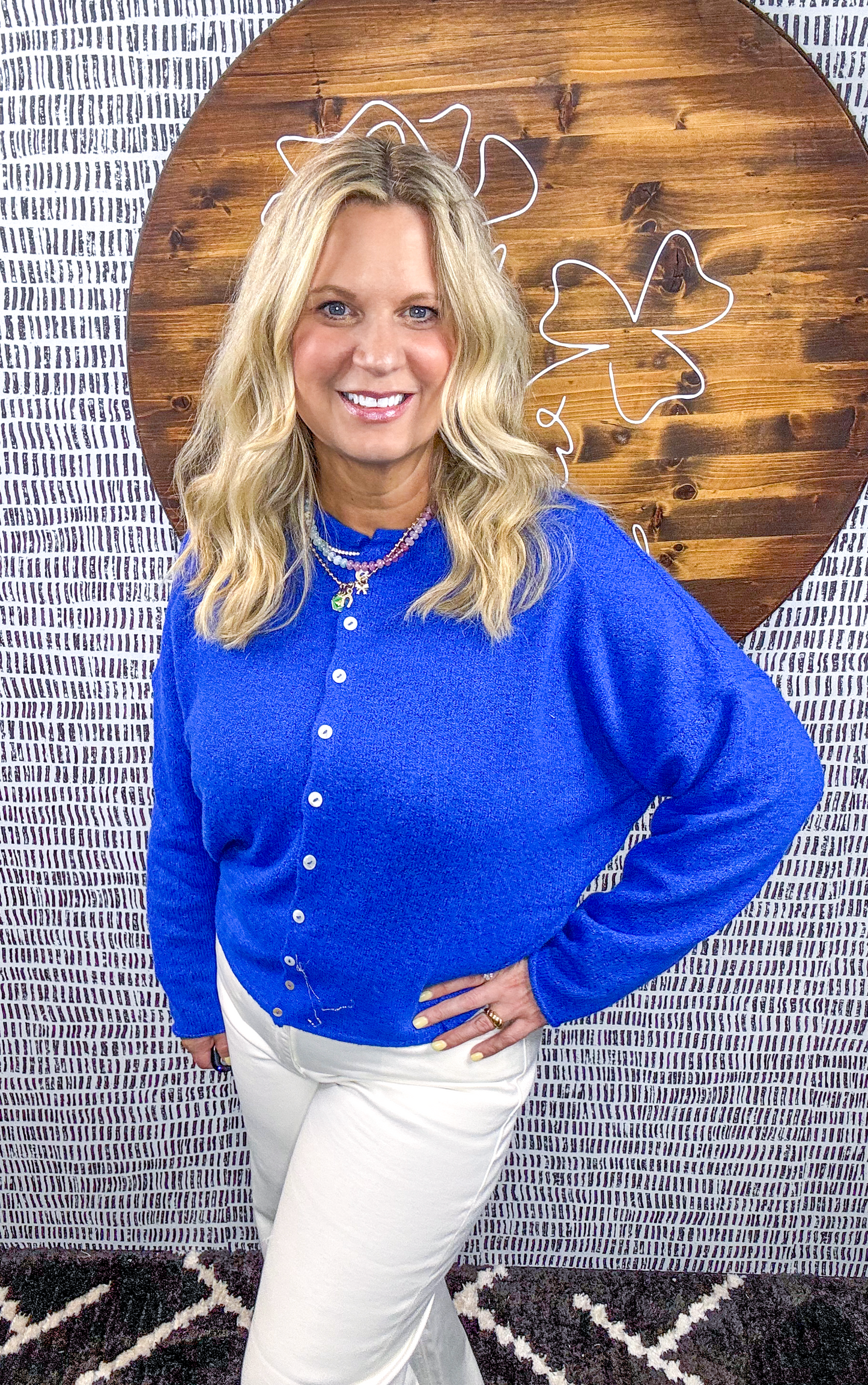 Front view of model wearing cobalt blue button-down cardigan with buttons and white pants – Erin Rose Boutique
