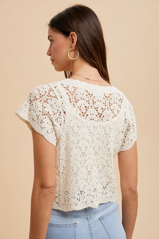 Back view of ivory crochet short sleeve top with scalloped hem, styled with light wash denim for a chic and breathable summer boutique look
