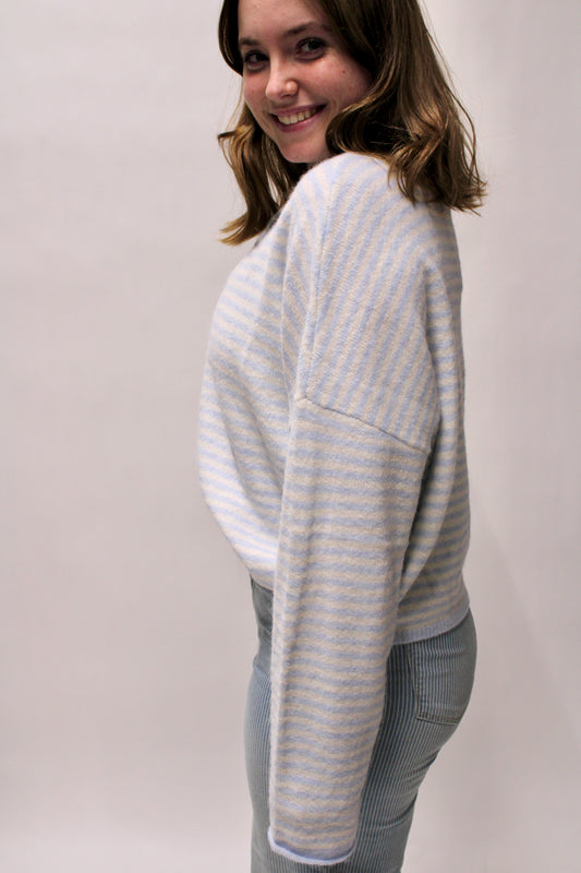 side view of pastel Soft blue and white striped knit cardigan with button front. Lightweight, relaxed and perfect for layering year-round.