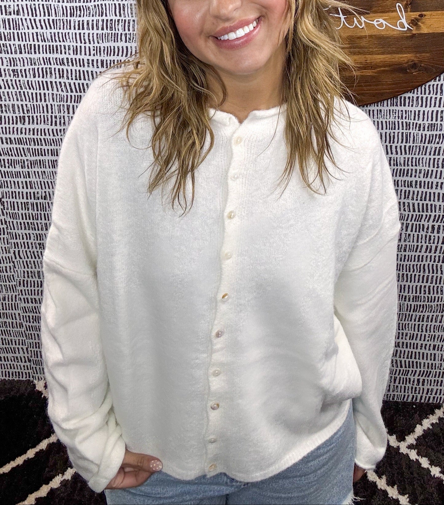 Model wearing white button-down cardigan with relaxed fit and pearl buttons, styled with light denim shorts – Erin Rose Boutique
