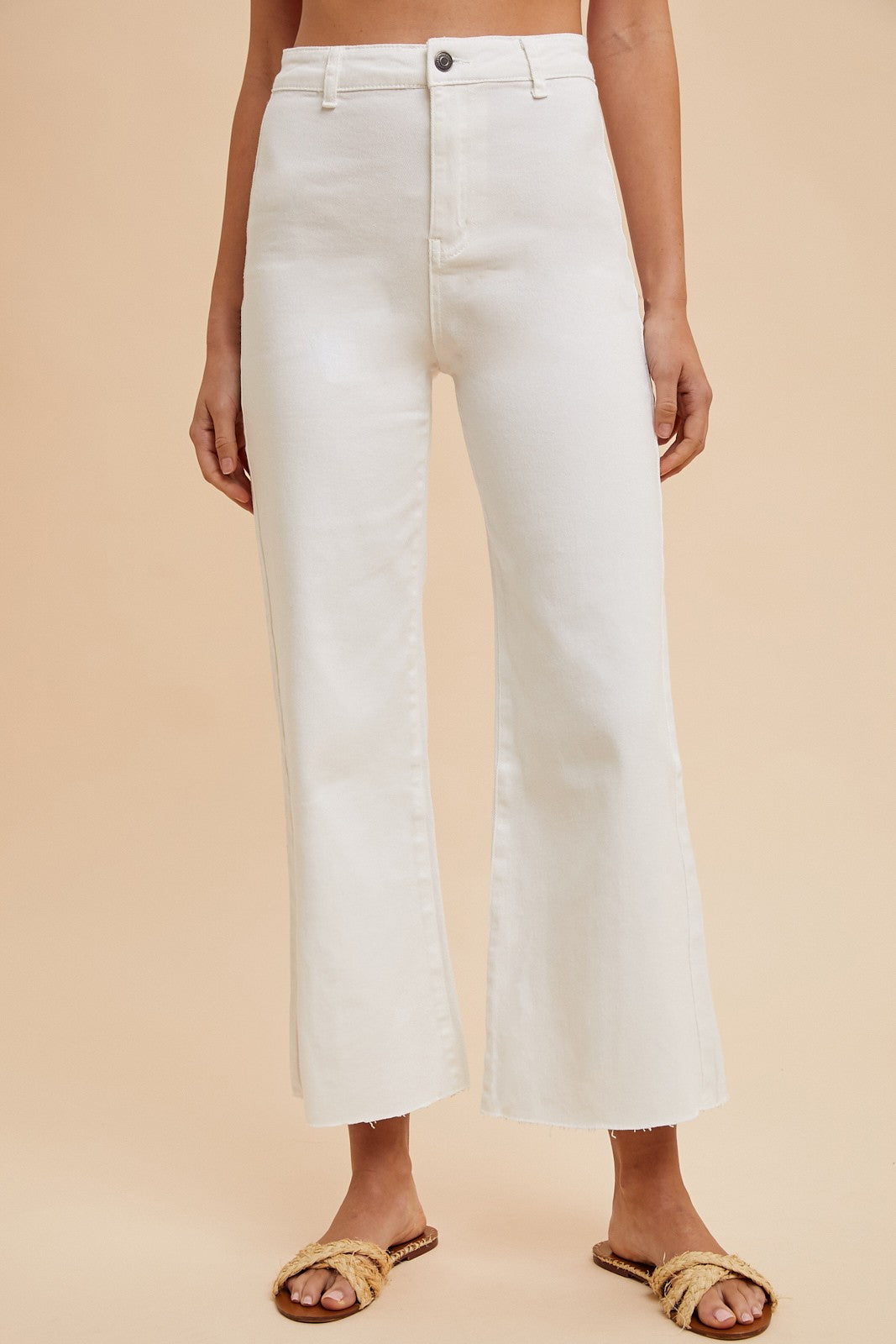 Woman wearing high rise white wide leg jeans with a cropped raw hem – trendy summer denim pants for women