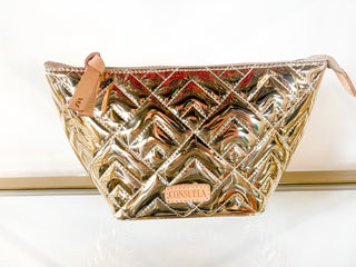 Consuela metallic silver quilted cosmetic bag with tan leather zipper pull on display