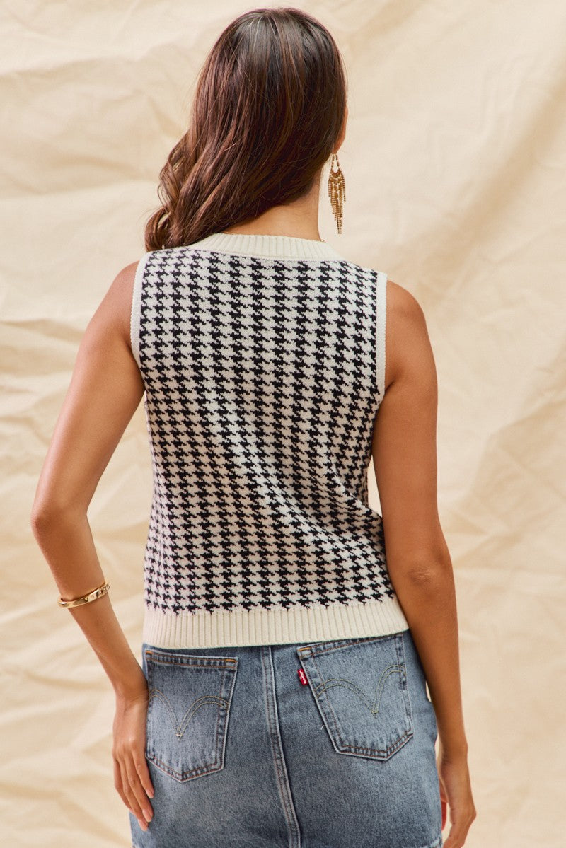 Woman wearing a houndstooth patterned sleeveless top with beige background