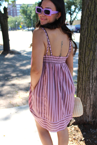 Back view of women’s striped smocked mini dresses in mauve pink 