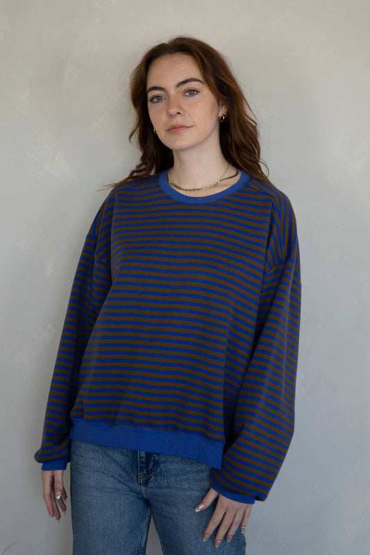 Woman wearing a blue and brown striped sweater available at Erin Rose Boutique