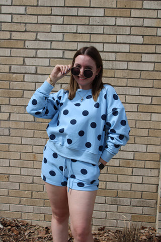 Woman wearing a Carolina Blue Polka Dot lounge shorts with matching sweatshirt top.