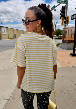 Casual summer outfit featuring the Butter Yellow Lennon Striped Top styled with printed pants and matching yellow accessories.