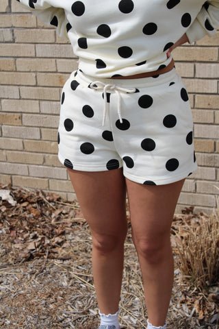 Woman wearing a pair of cream or butter yellow polka dot lounge shorts 