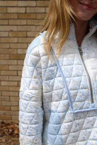 Close up of model wearing blue quilted patchwork pullover with half zip and relaxed fit styled as part of a matching set from Erin Rose Boutique