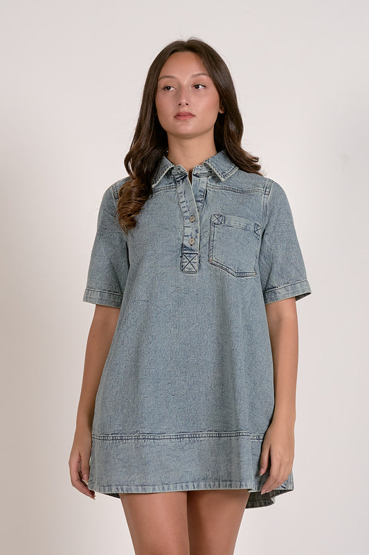Woman wearing a denim dress against a plain background