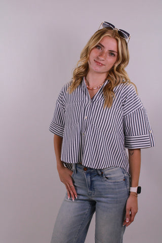 model wearing lightweight striped button down top with relaxed fit and short sleeves styled with denim from Erin Rose Boutique