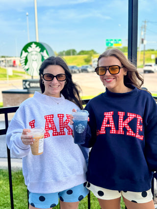 Cozy oversized LAKE graphic sweatshirts in ash gray and navy styled with playful polka dot shorts for an effortless lake-day outfit.