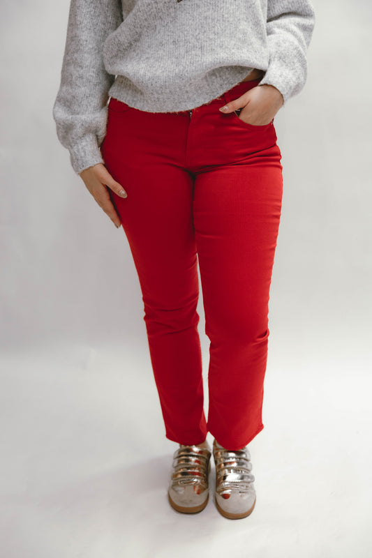 Person wearing red Dear John Anika Salsa Jeans and a gray sweater on a white background  available at Erin Rose boutique