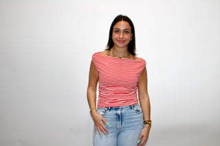 Woman wearing a red and white striped boat neck cap sleeve top styled with light wash jeans.