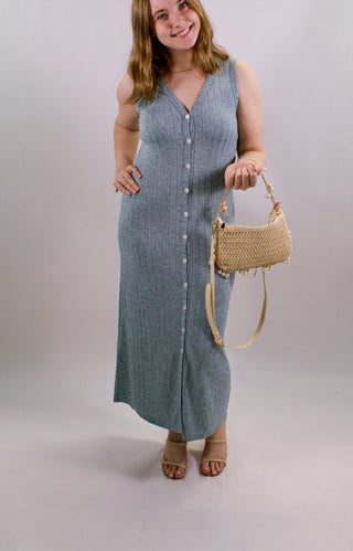 model wearing blue/grey ribbed button front midi dress with sleeveless design and flattering fit styled with sandals and woven handbag from Erin Rose Boutique