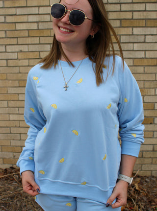 model wearing blue lounge sweatshirt with lemon embroidery styled as part of a matching set from Erin Rose Boutique