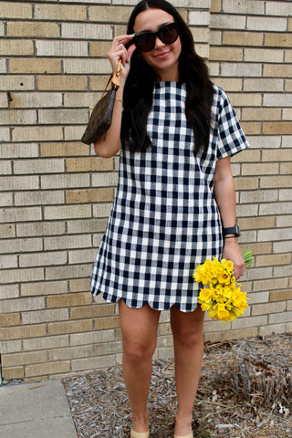model wearing navy gingham shift dress with scallop hem and relaxed fit styled with sandals from Erin Rose Boutique