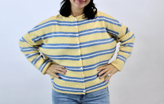 Model wearing a soft yellow cardigan with blue horizontal stripes and button front, styled with light wash jeans.