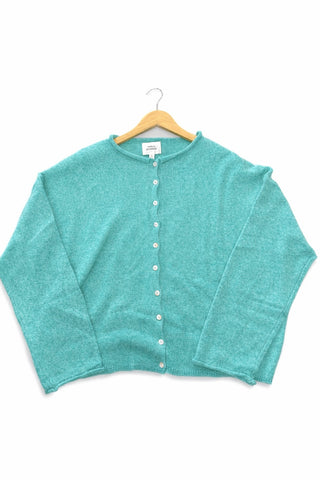 Teal cardigan on a hanger against a white background