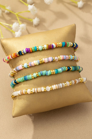 Stack of colorful agate and heishi beaded stretch bracelets with gold accents, sold separately