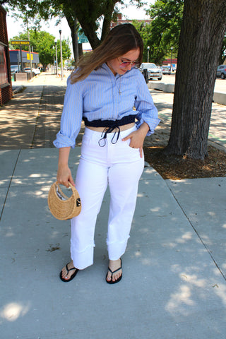 Blue striped button-up shirt with elastic drawstring waist and relaxed fit styled with white denim for a polished summer outfit