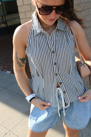 Black and white striped sleeveless collared blouse with button front styling paired with relaxed denim shorts for an effortless summer outfit
