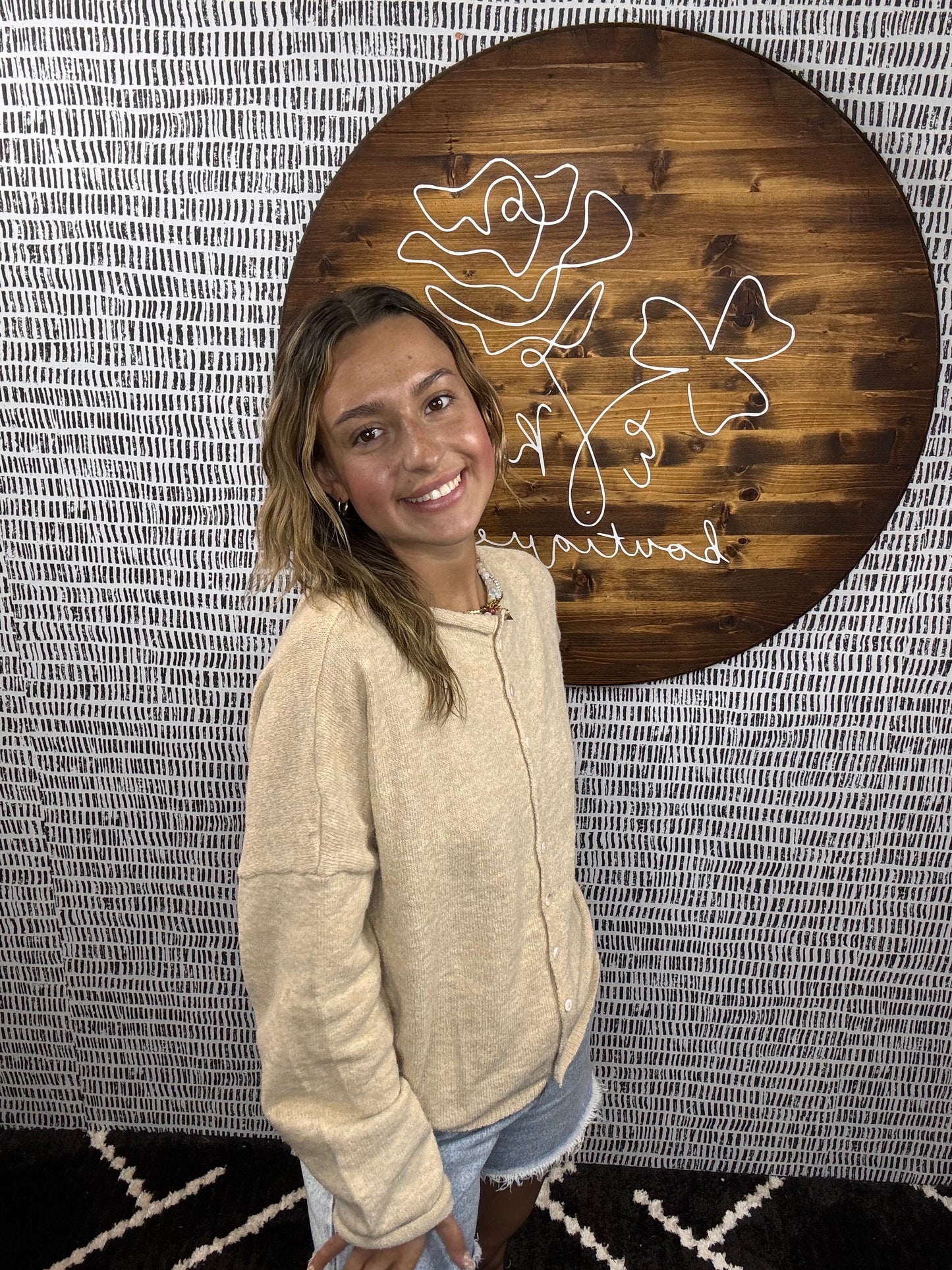 Side view of model wearing beige button-down cardigan styled with denim shorts – Erin Rose Boutique