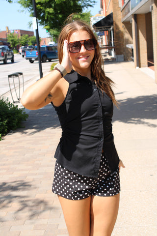 Black sleeveless collar top paired with polka dot shorts.
