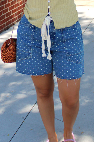 Women's blue polka dot denim barrel shorts with oversized utility pockets and a rope drawstring waistband.