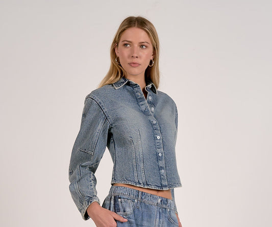 Woman wearing a denim barrel sleeve shirt against a plain background available at Erin Rose Boutique