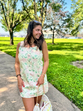 Cottage-inspired floral mini dress with functional buttons and front pockets.