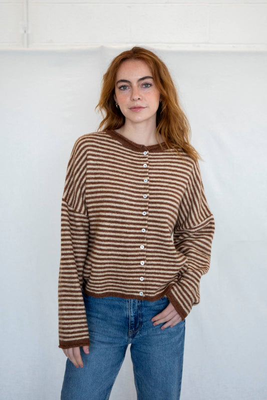 Woman wearing a brown and beige striped sweater with jeans available at Erin Rose Boutiqued