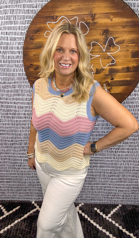 Model wearing multicolor chevron knit sleeveless sweater top with blue, pink, and tan stripes – Erin Rose Boutique