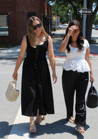 Women's casual black midi dress with functional buttons and a feminine gathered waist