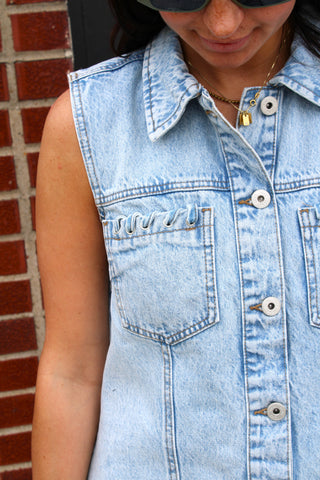 Close up of sleeveless light wash denim button front dress
