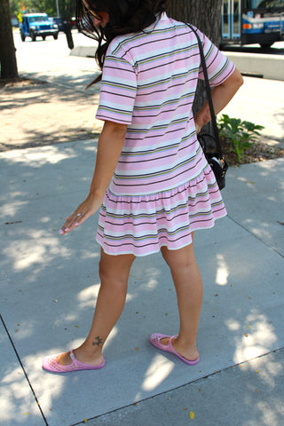 Back view of the Court Club Striped Polo Mini Dress featuring pastel multicolor stripes, a relaxed silhouette, short sleeves, and a feminine ruffle hem.
