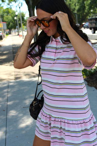Model wearing the Court Club Striped Polo Mini Dress featuring pastel stripes, a classic polo neckline, and a relaxed mini dress silhouette.