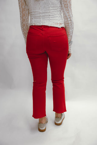 Person wearing red pants and a light-colored top on a white background