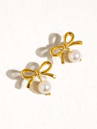 Gold bow stud earrings with pearl drop charm on white background – Erin Rose Boutique
