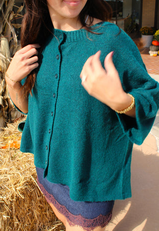 : Woman wearing Hailey deep teal button front cardigan sweater with relaxed sleeves and textured knit.