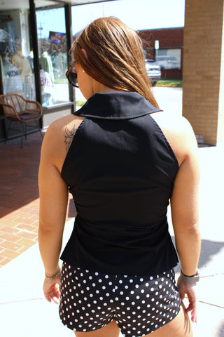 Back view of black sleeveless collared blouse with fitted silhouette.