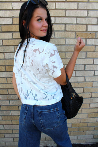 Back view of Lainey ivory floral lace short sleeve top styled with dark wash jeans