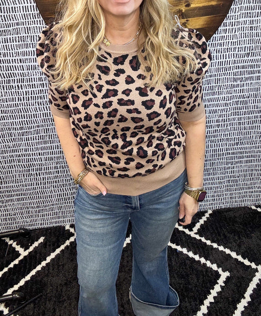 Woman wearing a leopard print puff sleeve knit top with dark wash denim jeans, styled for a trendy and casual boutique outfit