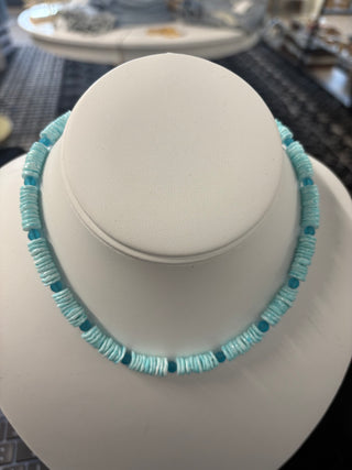 Light blue puka shell necklace with turquoise accent beads displayed on a white bust stand, summer beach jewelry 