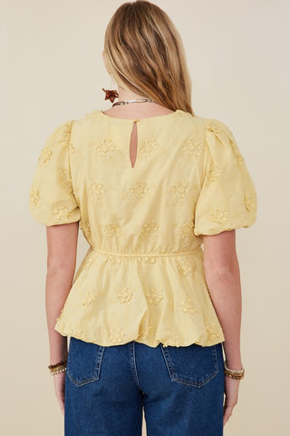 Backside of Model wearing Lydia crochet eyelet bubble peplum top with puff sleeves and bubble hem. Available at Erin Rose Boutique